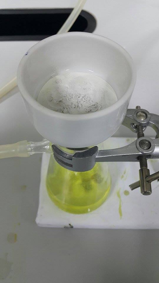 Funil de porcelana com um papel filtro circular, encaixado num frasco de vidro