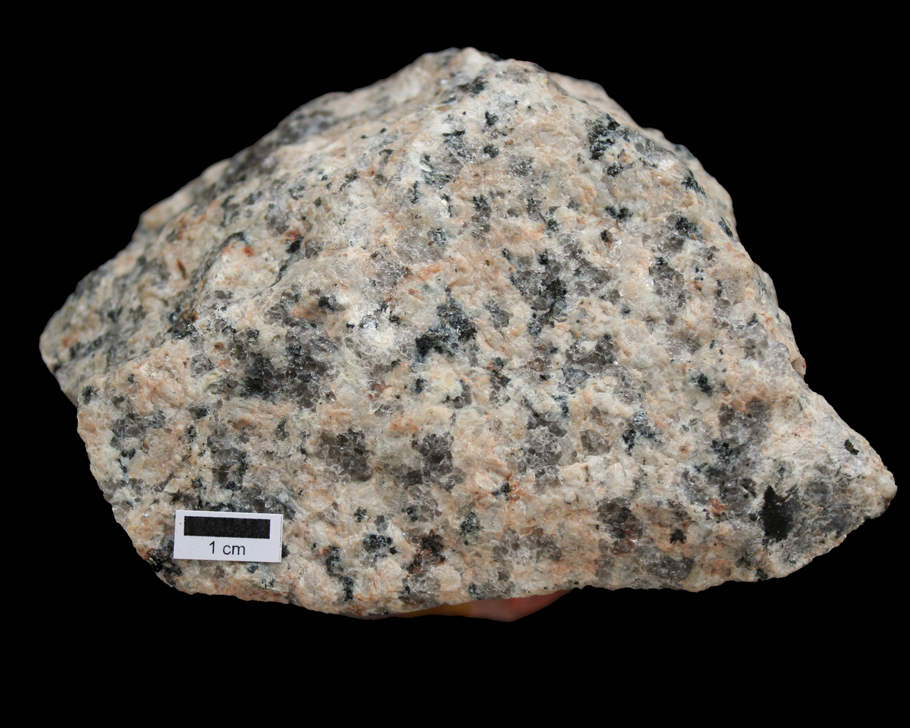 Amostra de granito, um material rosado com várias manchas claras e escuras