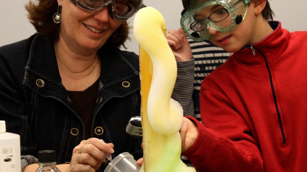 Uma proveta de laboratório, com espuma colorida saindo pelo topo